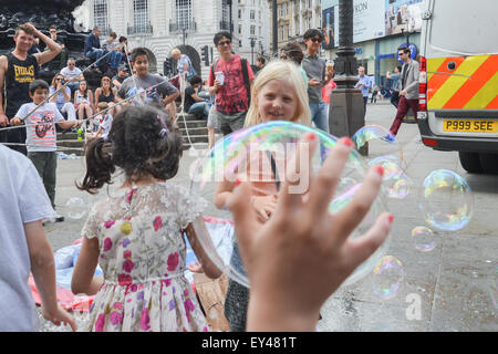 Piccadilly Circus, Londres, Royaume-Uni. 21 juillet 2015. Un homme crée des bulles de savon géantes pour amuser les enfants à Piccadilly Circus. © Ma Banque D'Images