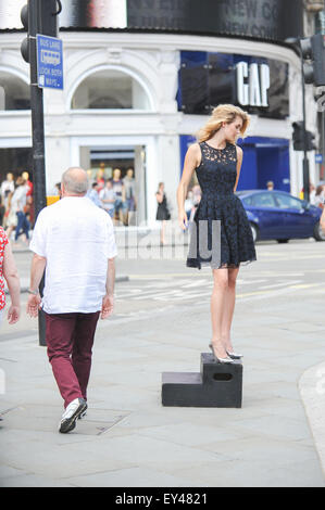 Piccadilly Circus, Londres, Royaume-Uni. 21 juillet 2015. Un modèle se trouve sur une case dans Piccadilly Circus lors d'un shoot de mode. © Matthieu Ch Banque D'Images