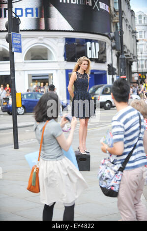 Piccadilly Circus, Londres, Royaume-Uni. 21 juillet 2015. Un modèle se trouve sur une case dans Piccadilly Circus lors d'un shoot de mode. © Matthieu Ch Banque D'Images