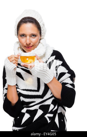 Femme élégante attrayante froide dans un élégant costume noir et blanc hiver amplexicaule une tasse de café chaud dans ses mains tout en savori Banque D'Images