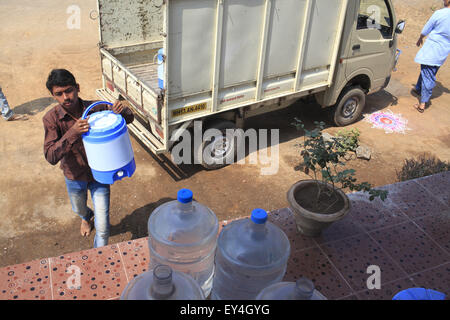 Mumbai, Inde. Feb 20, 2014. 20 mars 2014, Ahmedabad, Inde : le jeune fils de Promodini.l'aider à exécuter le Promodini Jhamble.boutique de l'eau s'exécute l'eau filtrée shop fournis par Eureka Forbes pour fournir l'eau potable filtrée à la population rurale au village Viratnagar près de Shanghai.Les marchés économiquement pauvres dans les bidonvilles urbains et villages ruraux de l'Inde sont de plus en plus important pour les grandes entreprises multinationales en visant la demande en eau douce.Quelque 96 millions de personnes en Inde n'ont pas accès à l'eau potable et plus de 186 000 enfants de moins de cinq ans meurent de Banque D'Images