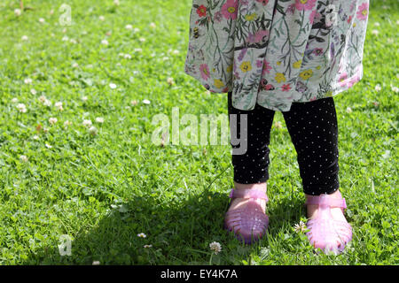 Bébé fille jambes debout dans grass meadow, Cardiff, Royaume-Uni Banque D'Images