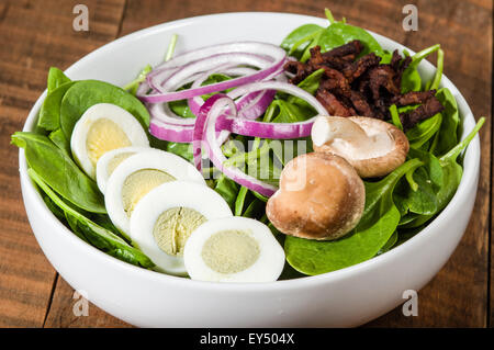 Bol de salade d'épinards et d'oeufs aux champignons et oignons Banque D'Images