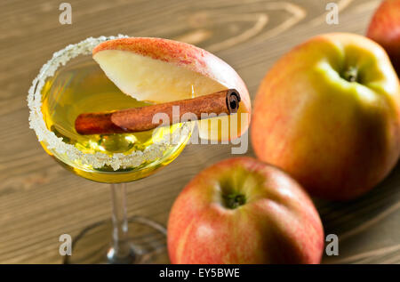 Cocktail avec de la pomme et cannelle sur table en bois Banque D'Images