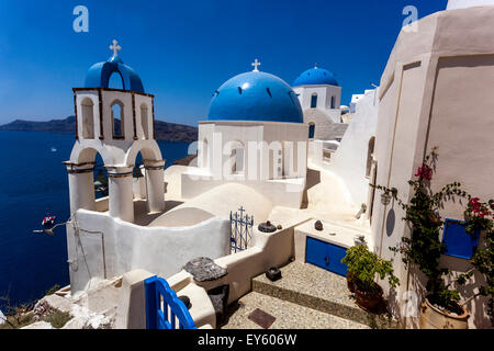 Vue de l'églises aux dômes bleus dans le village d'Oia par la falaise, Santorini, Cyclades, îles grecques, Grèce, Europe Banque D'Images