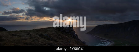 Female hiker montres soleil de minuit au-dessus de la mer de crête de montagne, Nonstind Vestvågøy, îles Lofoten, Norvège Banque D'Images