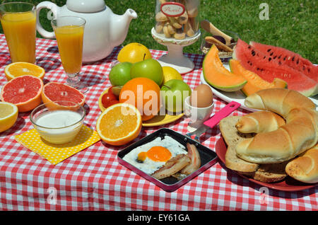 Le petit-déjeuner ou brunch avec café, du bacon et des oeufs, oeuf mollet, croissants, pain, biscuits, céréales, jus d'orange et de fruits Banque D'Images