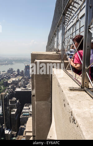 Les touristes en haut de l'Empire State Building, de la plate-forme d'observation du 86e étage, la vue de Manhattan, New York City, USA. Banque D'Images