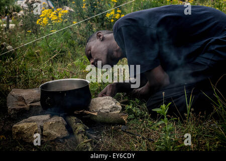 Calais, France. 22 juillet, 2015. Idris, 25 d'Érythrée la préparation de l'endroit du feu pour faire cuire son repas (crédit Image : © Grant Vélaire via fil Zuma Zuma) Crédit : Press, Inc./Alamy Live News Banque D'Images