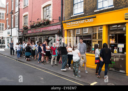 Les gens faire la queue à l'extérieur du Petit-déjeuner populaire club cafe restaurant, d'Arblay Street, Soho, London UK Banque D'Images