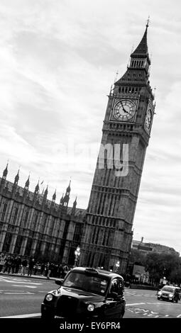 Taxi noir passant devant les Chambres du Parlement et Big Ben Banque D'Images