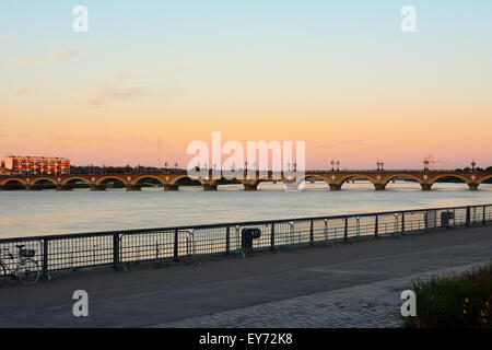 Pont de Pierre pont sur la Garonne au coucher du soleil à partir de la rive gauche à Bordeaux, France Banque D'Images