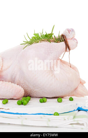 Poulet entier biologiques crus avec des herbes sur une planche à découper isolé sur blanc, préparé pour la cuisson. La cuisine culinaires. Banque D'Images