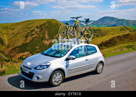 Une voiture avec deux vélos sur la galerie de conduire à travers les collines du Shropshire en Angleterre, Royaume-Uni. Banque D'Images