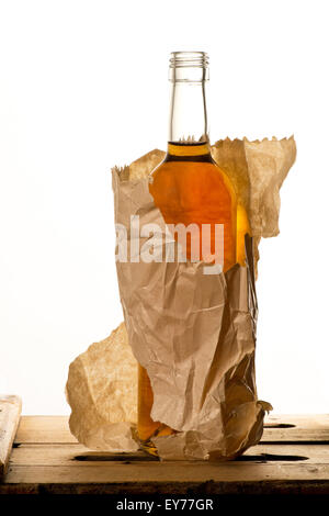Bouteille de disque liquer dans le sac en papier sur le livre blanc Banque D'Images
