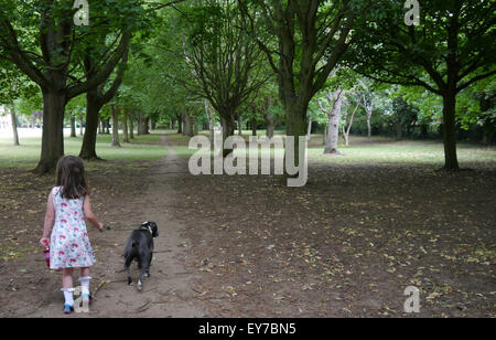 Wittering Cambridgeshire, Royaume-Uni. 23 juillet, 2015. Météo matin refroidisseur d'une jeune fille prend son chien pour une promenade dans le parc local au cours de l'été vacances scolaires. Credit : Clifford Norton/Alamy Live News Banque D'Images