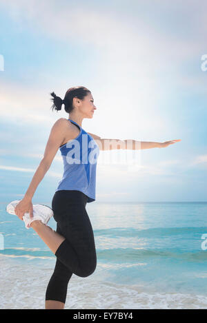 Young woman exercising par mer Banque D'Images