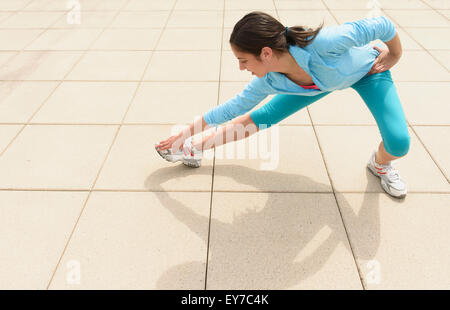 Teenage girl (14-15) stretching Banque D'Images