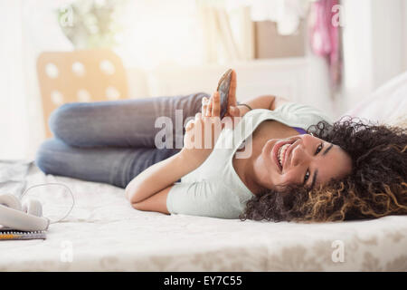 Portrait of teenage girl (16-17) des SMS dans la chambre Banque D'Images