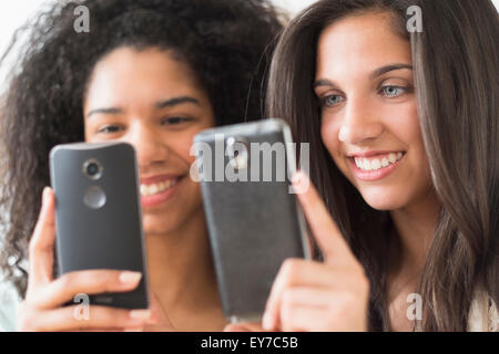 Adolescentes (14-15, 16-17) avec les téléphones intelligents Banque D'Images