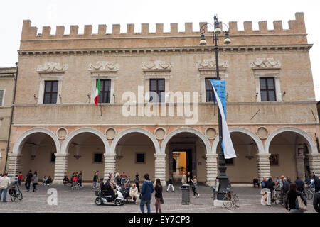 Piétons et cyclistes en face du Palazzo del Governo, Pesaro. Banque D'Images