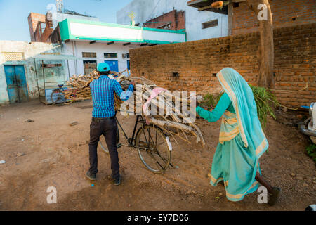 L'homme et la femme transporter le bois sur une bicyclette à Khajuraho, Madhya Pradesh, Inde Banque D'Images