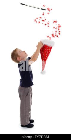 Little Boy holding wizard hat, étoiles effusion de hat, entraîné par Magic wand Banque D'Images