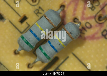 Macro-photo des résistances en céramique sur une carte de circuit imprimé (PCB) à montage traversant. Concept de résistance, résistance électrique, composants traversants. Banque D'Images