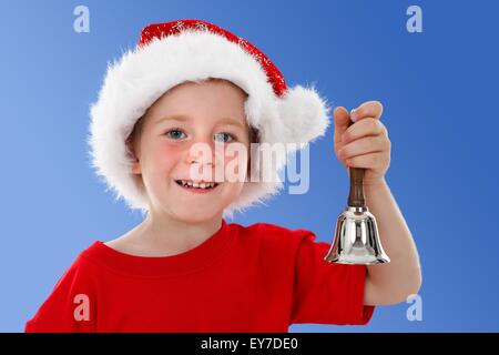 Cute boy sonnerie hand bell en face de lui, fond bleu Banque D'Images