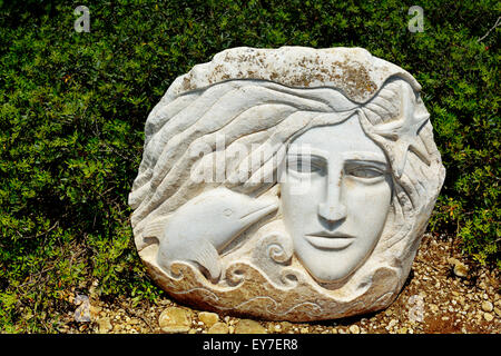 Visage de femme et un dauphin sculptés sur la pierre de marbre blanc Banque D'Images