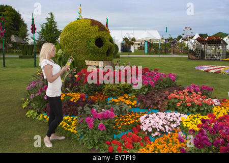 Cheshire, Royaume-Uni. 23 juillet, 2015. Ashleigh Edwards ne peut pas résister à l'arôme de la 'Polar Star' roses. Ashleigh âgés de 24 de Southport, Merseyside est une première visite à l'exposition florale de Tatton Park et est en admiration devant les belles fleurs de l'exposition. Credit : Cernan Elias/Alamy Live News Banque D'Images