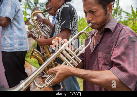 Des villageois jouant de la trompette et du saxophone lors d'une représentation d'orchestre rural pour accueillir des touristes à Rumahkay, West Seram, Maluku, Indonésie. Banque D'Images