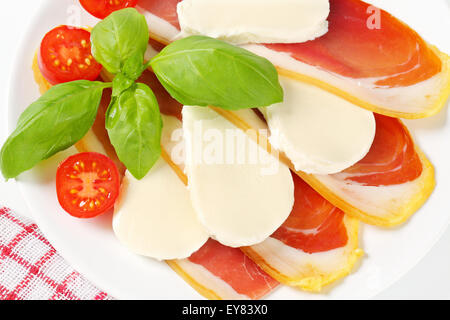 Tranches de jambon de pays et à la mozzarella avec tomates et basilic frais Banque D'Images