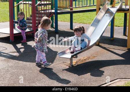 Trois petites filles jouent ensemble dans l'aire de jeux Banque D'Images