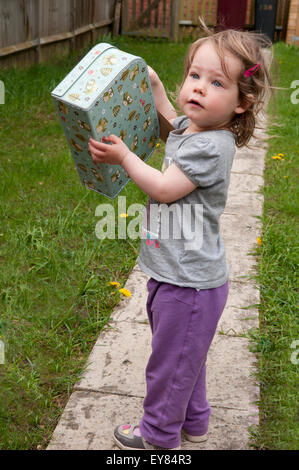 Petite fille heureuse avec sa mini valise Banque D'Images