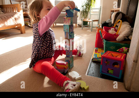 Petite fille construction d'une tour avec des blocs de couleur Banque D'Images