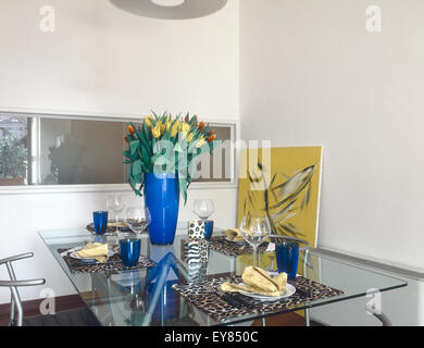 Détail de table dressée dans la salle à manger avec blue vase de tulipes Banque D'Images