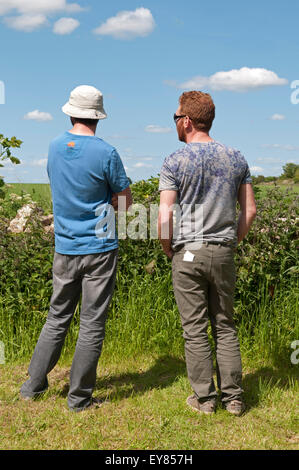 Vue arrière des deux hommes parlant dans le jardin Banque D'Images