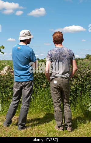 Vue arrière des deux hommes parlant dans le jardin Banque D'Images