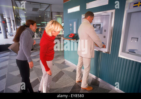 Les personnes en attente d'utiliser les guichets automatiques bancaires à Stockholm Banque D'Images