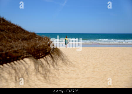 Dame sur plage de sable doré et bleu ciel et mer bleue. Banque D'Images