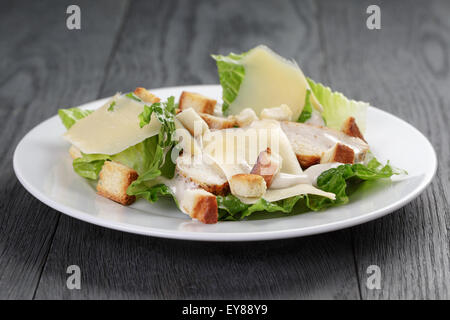 Salade césar avec poulet sur table en chêne Banque D'Images