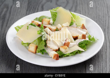 Salade césar avec poulet sur table en chêne Banque D'Images