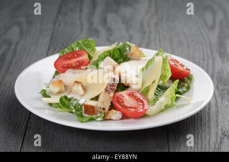 Salade césar avec poulet sur table en chêne Banque D'Images