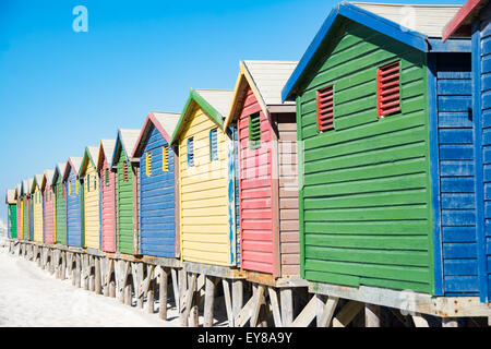 Des bains colorés à Muizenberg, Cape Town, Afrique du Sud, debout dans une ligne. Banque D'Images