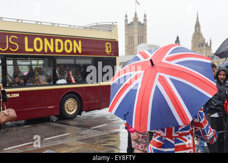 Westminster, London, UK. 24 juillet 2015. Météo britannique. La pluie à Londres en tant que touristes et gastronome de couvrir sous des parasols. Crédit : Matthieu Chattle/Alamy Live News Banque D'Images