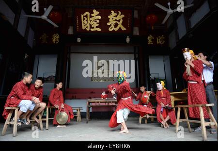 Nanfeng, province de Jiangxi en Chine. 23 juillet, 2015. La pratique des enfants dans la danse Nuo dans hall ancestral Village Shiyou, Sanxi Canton de Nanfeng, comté de la Province de Chine orientale, le 23 juillet 2015. Danse Nuo utilisée pour être les rituels sacrificiels dans la Chine ancienne pour expulser les esprits mauvais et prier pour de bonnes récoltes. Vous Genming, un héritier de Nuo danse, mis en place cette formation adolescent de poursuivre des cours de l 'fossile vivant de l'ancienne danse' il y a environ une décennie. © Chen Zixia/Xinhua/Alamy Live News Banque D'Images