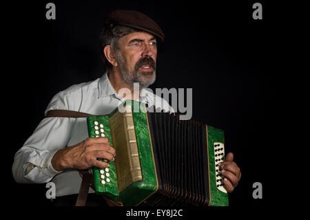 Portrait (faible) d'une vieille paysanne ukrainienne de chanter tout en jouant de l'accordéon bouton Banque D'Images