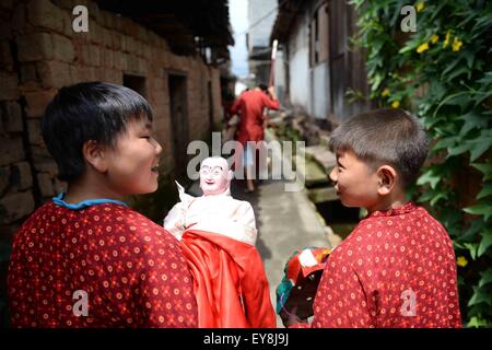 Nanfeng, province de Jiangxi en Chine. 23 juillet, 2015. Luo Hao (L), tenant le Nuo Dieu poupée, va à la formation en classe avec son ami Shiyou, Sanxi Village Canton de Nanfeng, comté de la Province de Chine orientale, le 23 juillet 2015. Danse Nuo utilisée pour être les rituels sacrificiels dans la Chine ancienne pour expulser les esprits mauvais et prier pour de bonnes récoltes. Il y a environ une décennie, vous Genming, un héritier de Nuo danse, mis en place une classe d'une adolescente du Village de poursuivre Shiyou Nuo danse, qui est reconnue comme étant 'le fossile vivant de l'ancienne danse chinoise' . © Chen Zixia/Xinhua/Alamy Live News Banque D'Images