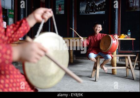 Nanfeng, province de Jiangxi en Chine. 23 juillet, 2015. Zichong Wu (R) pratiques tambour de danse Nuo dans Village Shiyou, Sanxi Canton de Nanfeng, comté de la Province de Chine orientale, le 23 juillet 2015. Danse Nuo utilisée pour être les rituels sacrificiels dans la Chine ancienne pour expulser les esprits mauvais et prier pour de bonnes récoltes. Il y a environ une décennie, vous Genming, un héritier de Nuo danse, mis en place une classe d'une adolescente du Village de poursuivre Shiyou Nuo danse, qui est reconnue comme étant 'le fossile vivant de l'ancienne danse chinoise' . © Chen Zixia/Xinhua/Alamy Live News Banque D'Images